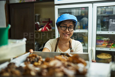 Buy stock photo Portrait of a happy cook putting a tray of food on the pass in a Thai restaurant