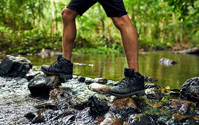 Buy stock photo Cropped shot of an unidentifiable hiker crossing a stream while exploring in the woods