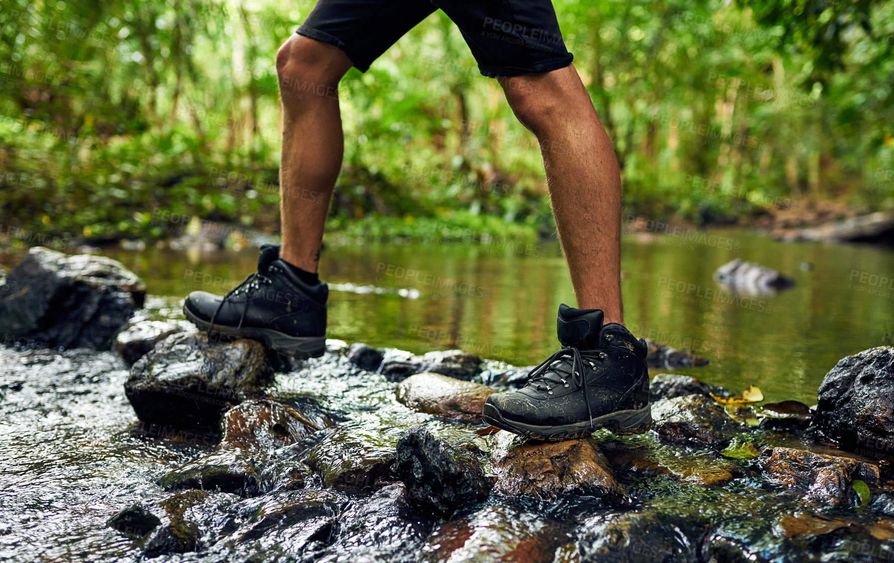 Buy stock photo Person, legs and hiking with river in forest for journey or outdoor adventure in wilderness. Feet of hiker trekking on rocks for exploration, walking or travel in woods, nature or natural environment