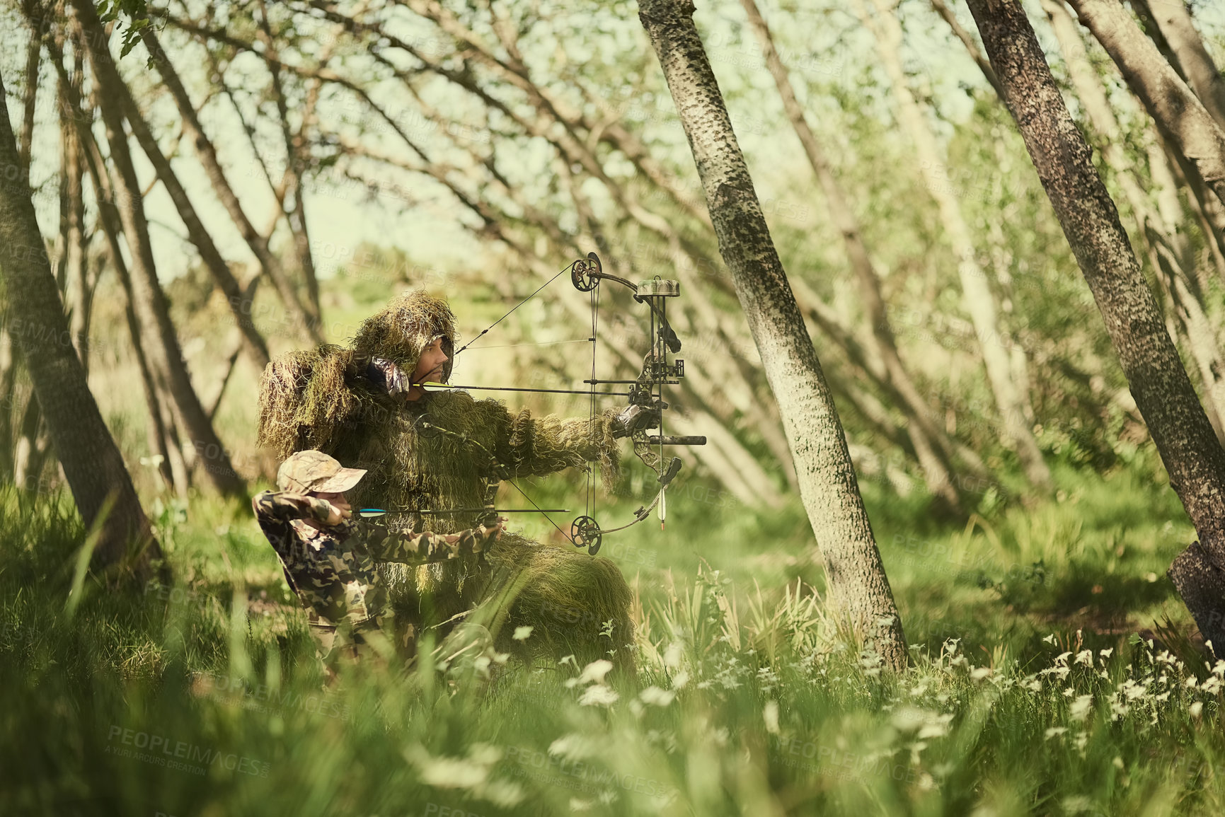 Buy stock photo Shot of a father and son in camouflage hunting with bows and arrows in the woods