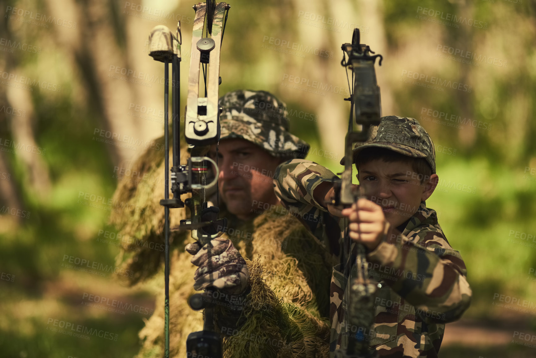 Buy stock photo Portrait of a father and son in camouflage hunting with bows and arrows in the woods