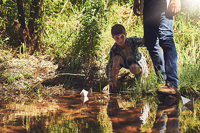 Buy stock photo Father, child and paper boat in a river for fun, learning and adventure with support, care and bonding in nature together. Origami, ship or kid with dad at a lake for creative, race or travel journey