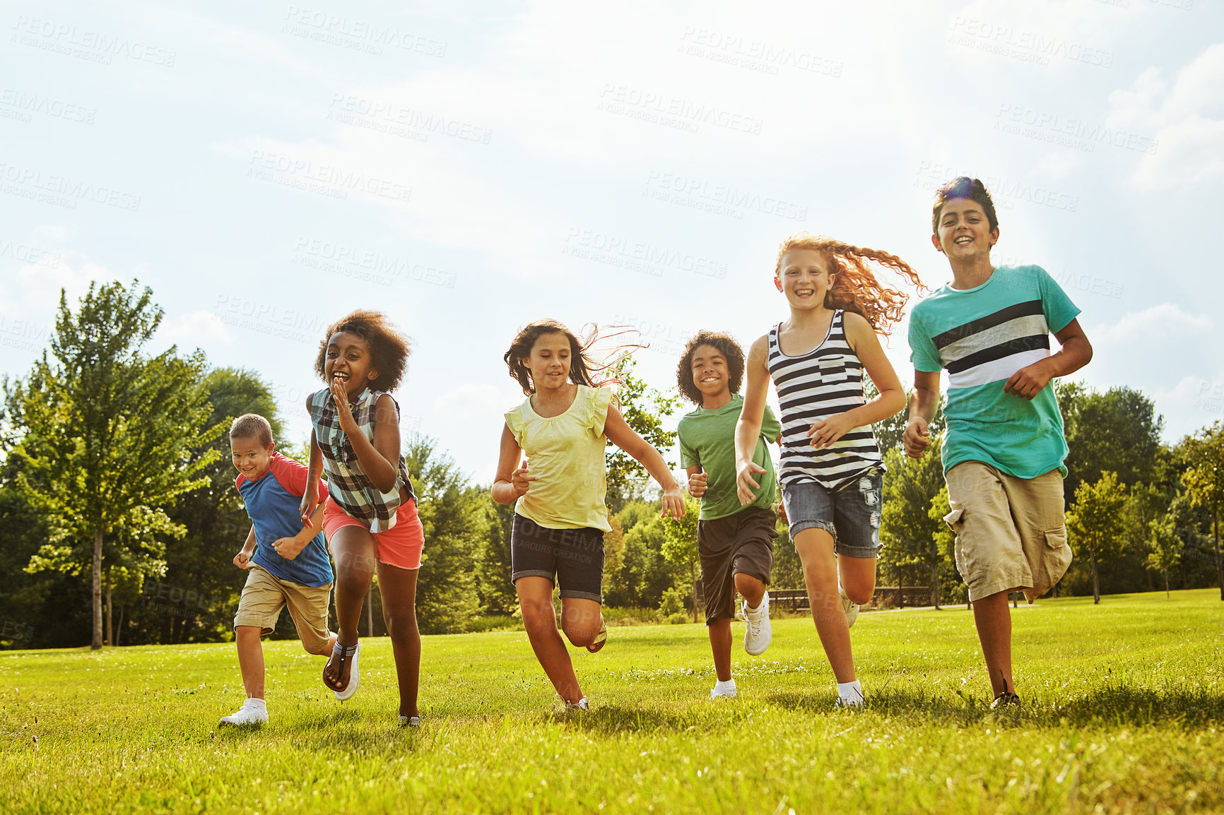 Buy stock photo Happy children, diversity and running with friends in nature for fun, playful day or summer at park. Group of excited kids or youth enjoying sunny outdoor holiday or weekend on grass field together