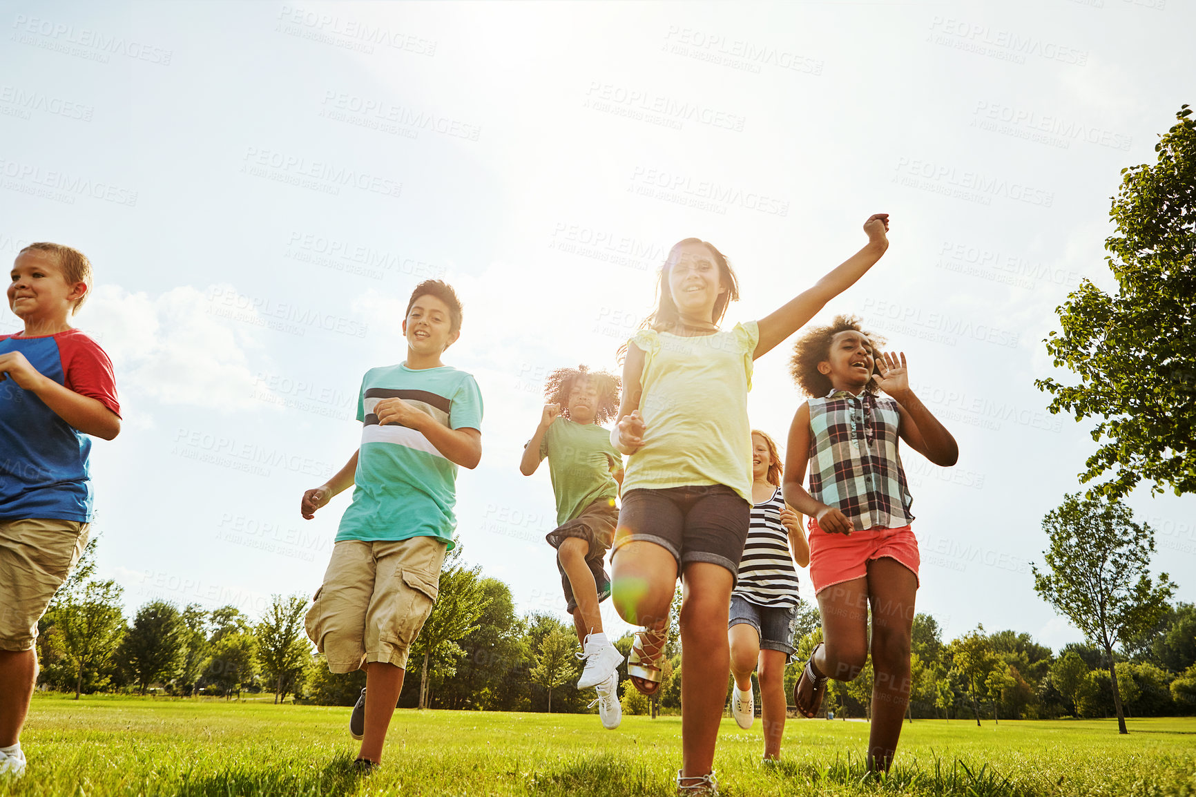 Buy stock photo Happy children, diversity and playing with youth in nature for fun, playful day or summer at park. Group of excited kids or friends enjoying sunny outdoor holiday or weekend on grass field together