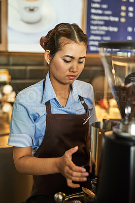 Buy stock photo Shot of a focused young barista working behind the cash register in a coffee shop