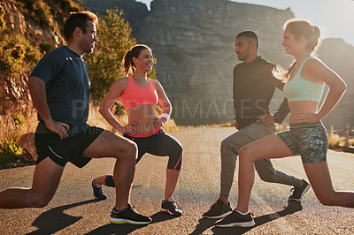 Buy stock photo Shot of a group of friends stretching before their run