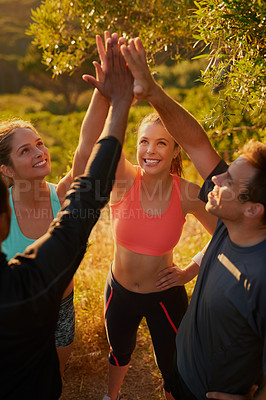 Buy stock photo Shot of a fitness group giving each other a high five as a team