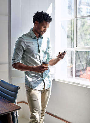 Buy stock photo Cropped shot of a young designer texting on his cellphone in an office