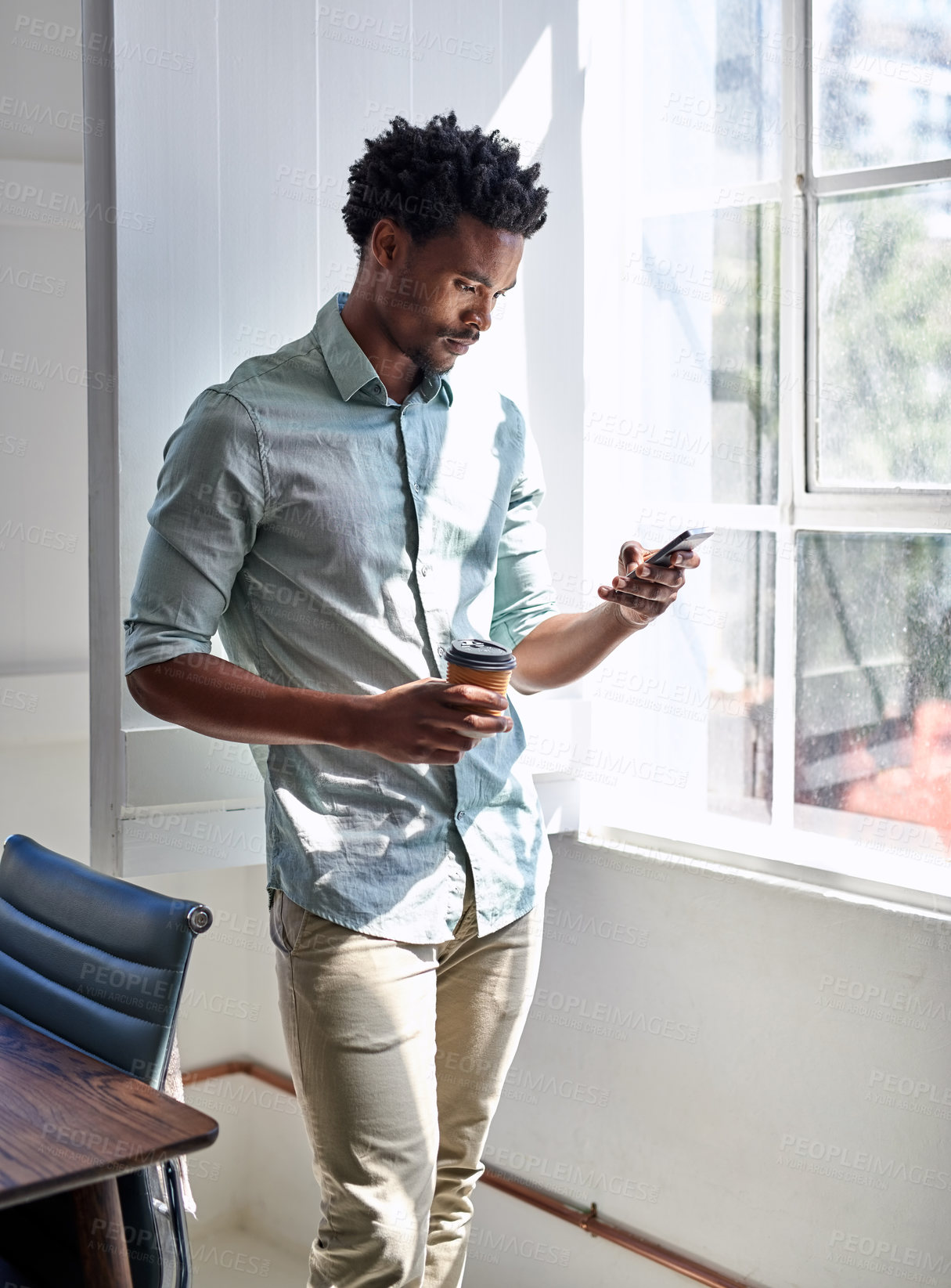 Buy stock photo Office, window and black man with phone, coffee cup and scroll on social media, email or online chat. Networking, schedule and creative professional with smartphone for business connection with drink