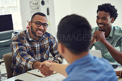 Buy stock photo Cropped shot of designers shaking hands during a meeting in an office