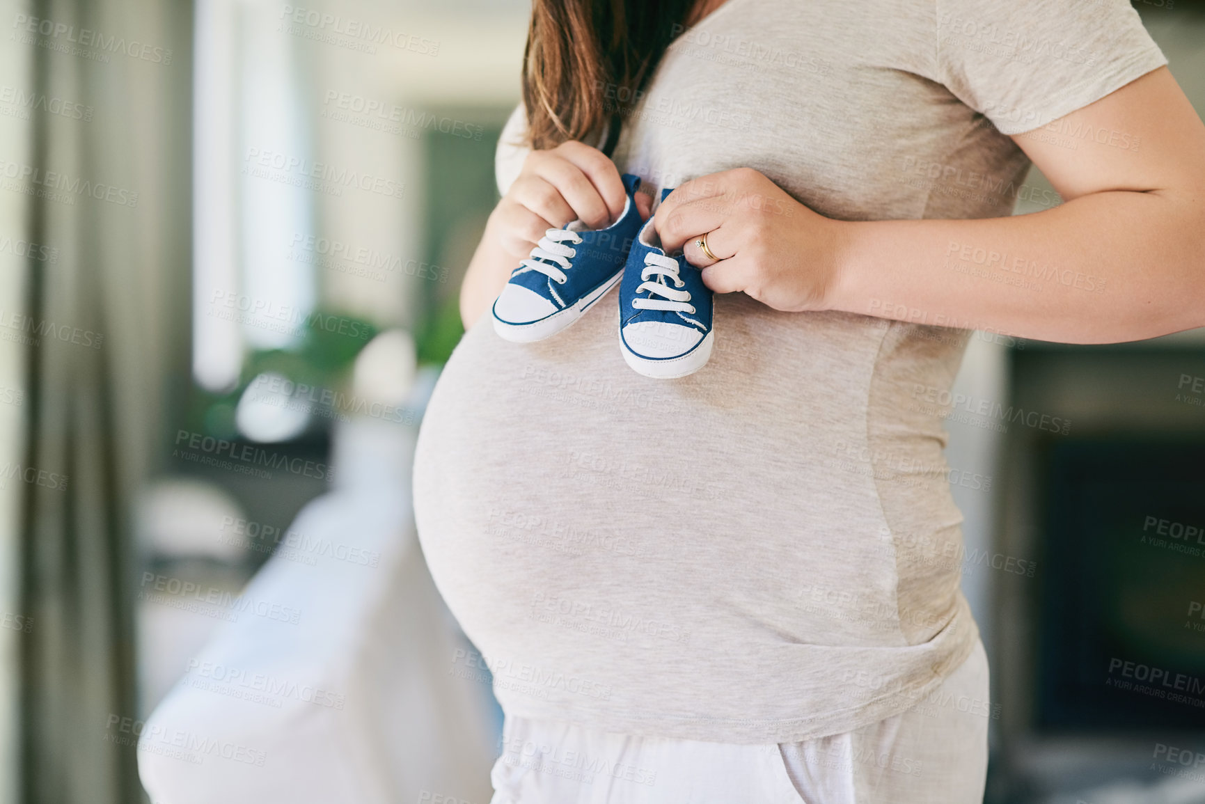 Buy stock photo Pregnant, woman and shoes on belly in home for reveal of boy gender with blue color, journey and experience of pregnancy. Mother to be, holding sneakers and stomach for love or bonding and motherhood