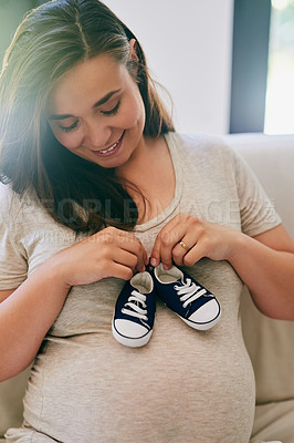 Buy stock photo Happy, pregnant woman and shoes on belly in home for reveal of boy gender, journey and experience of pregnancy. Mother to be, holding sneakers and stomach for love or bonding and motherhood with care