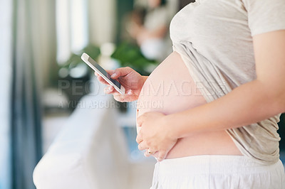 Buy stock photo Shot of an unrecognizable pregnant woman sending a text from home
