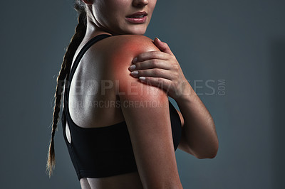 Buy stock photo Cropped shot of a sporty young woman suffering from a shoulder injury