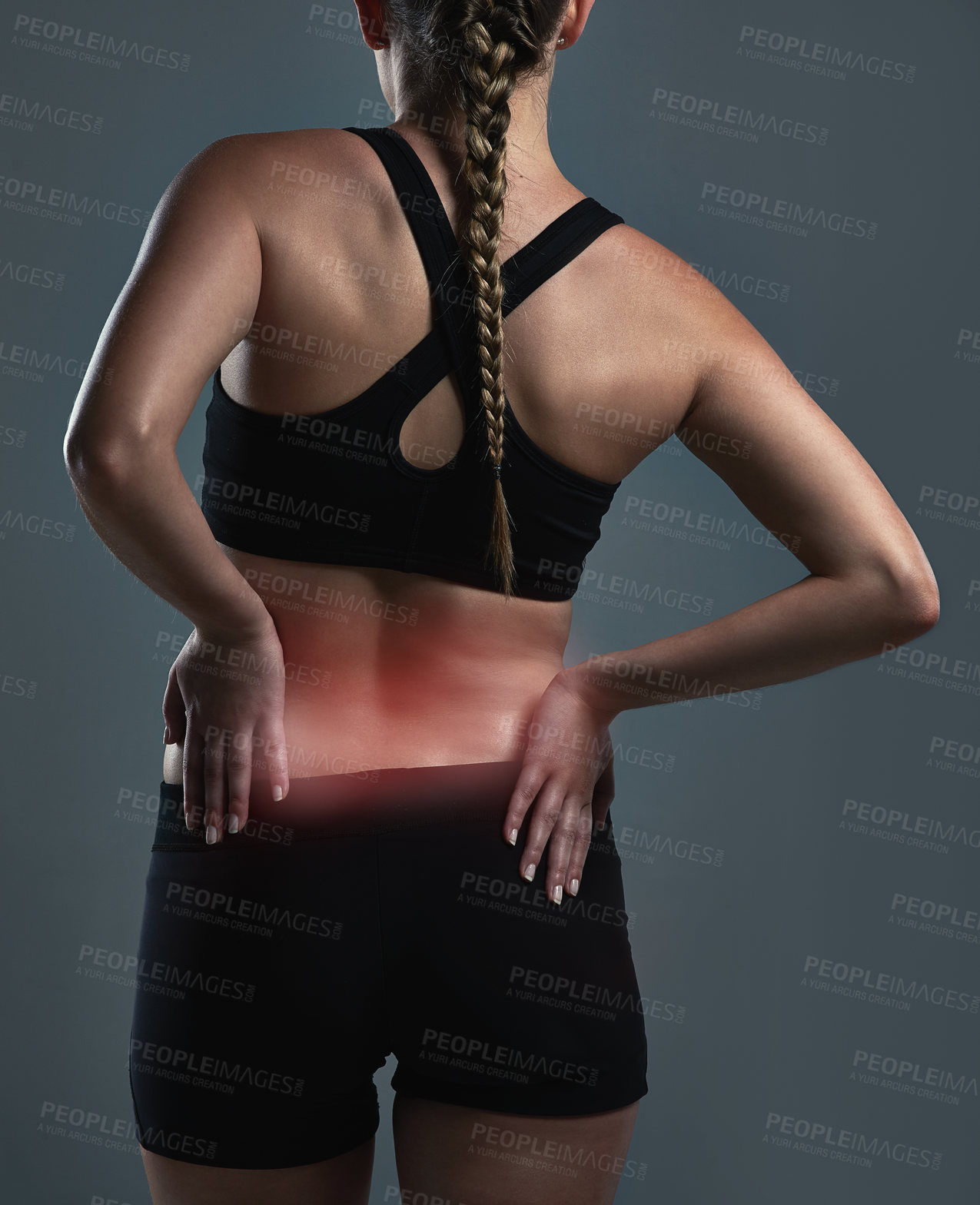 Buy stock photo Rearview shot of a sporty young woman suffering from backache