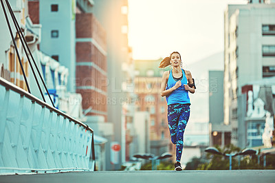 Buy stock photo Shot of a young woman out in the city for her morning run