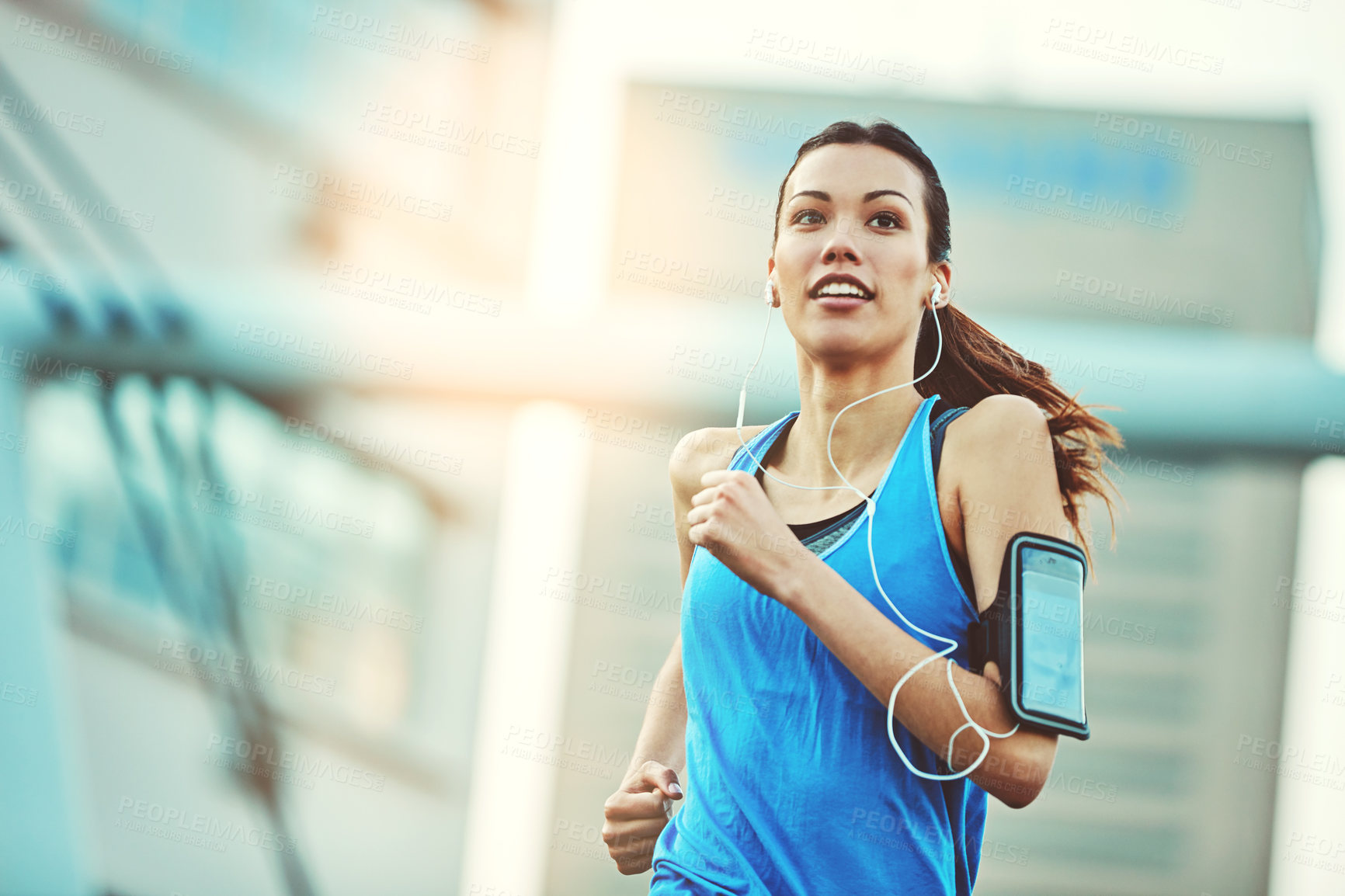 Buy stock photo Shot of a young woman out in the city for her morning run