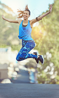 Buy stock photo Shot of a young woman jumping in mid air after her workout
