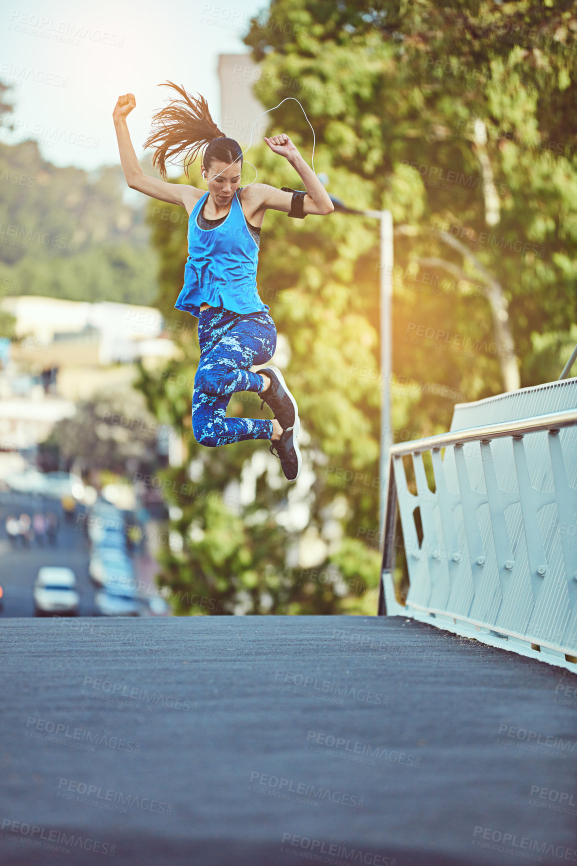 Buy stock photo Shot of a young woman jumping in mid air after her workout