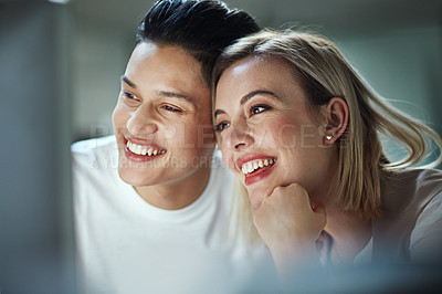 Buy stock photo Shot of two young businesspeople showing each other affection while sitting in the office