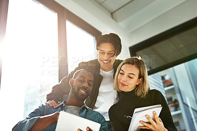 Buy stock photo Shot of a group of young businesspeople brainstorming with a tablet in the office