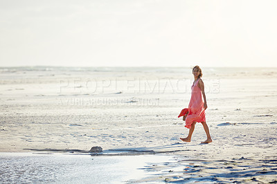 Buy stock photo Shot of a woman walking on the beach