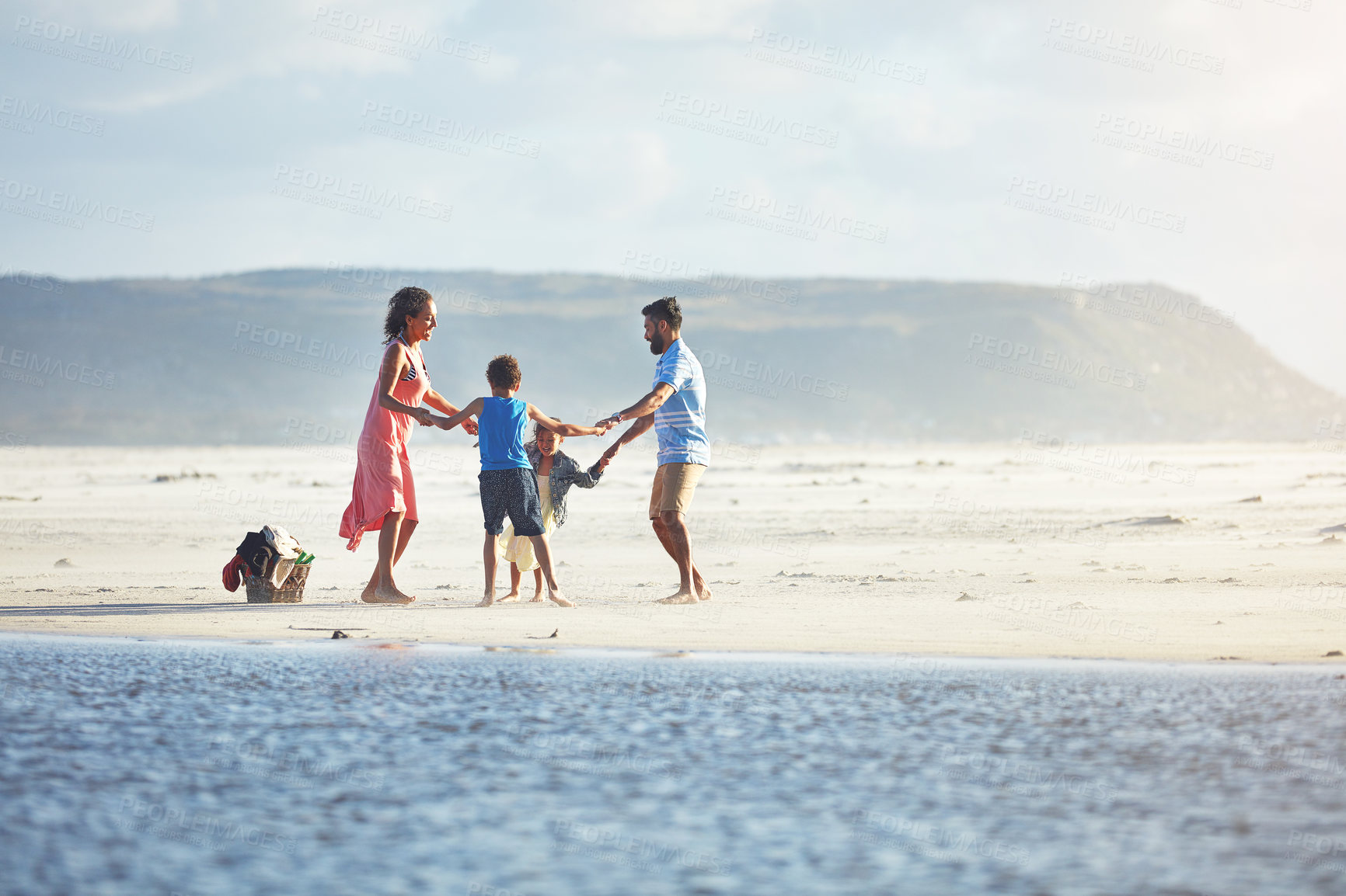 Buy stock photo Shot of a family of four enjoying a day at the beach