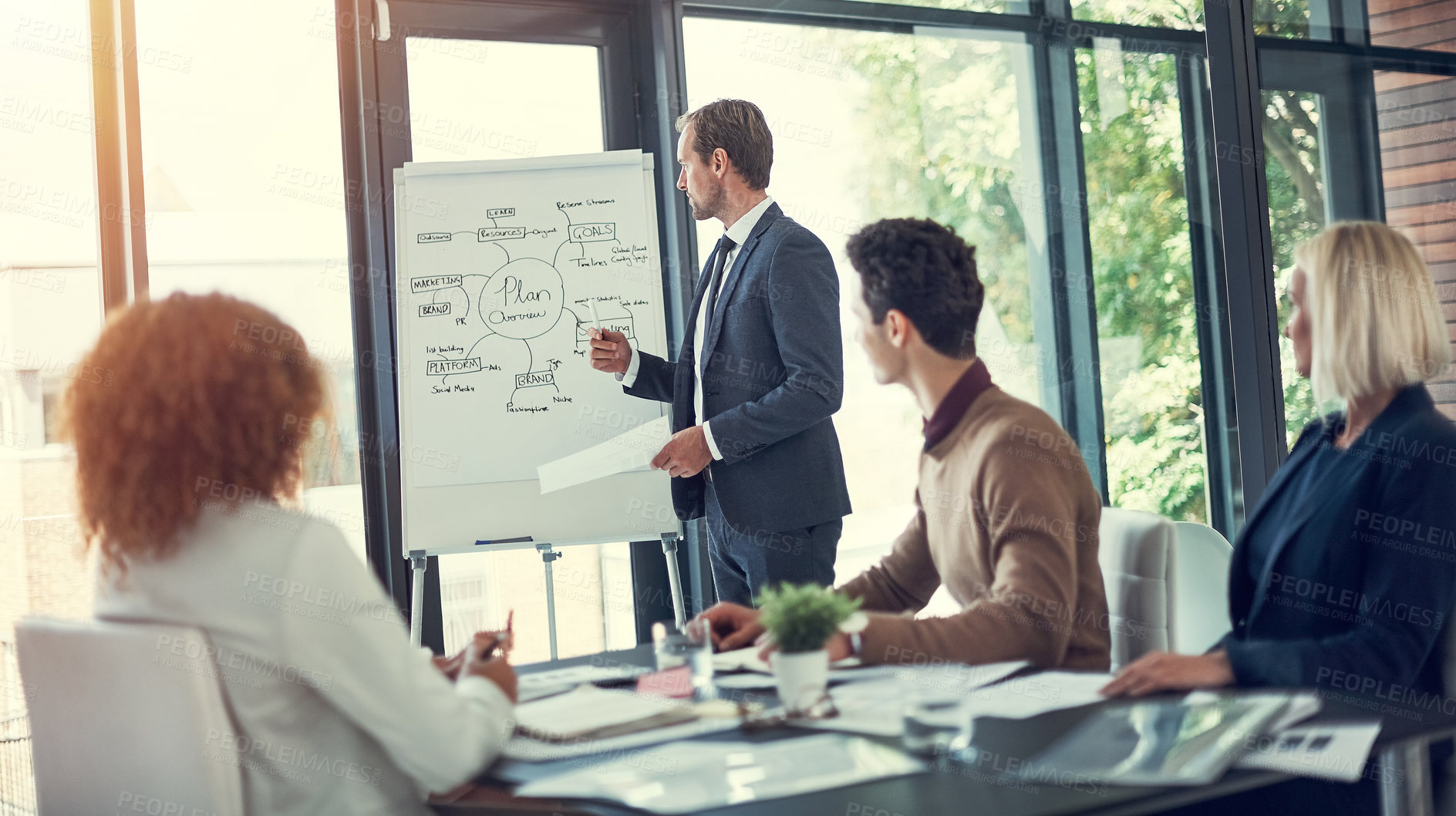 Buy stock photo Cropped shot of a businessman giving a presentation to his colleagues in the boardroom