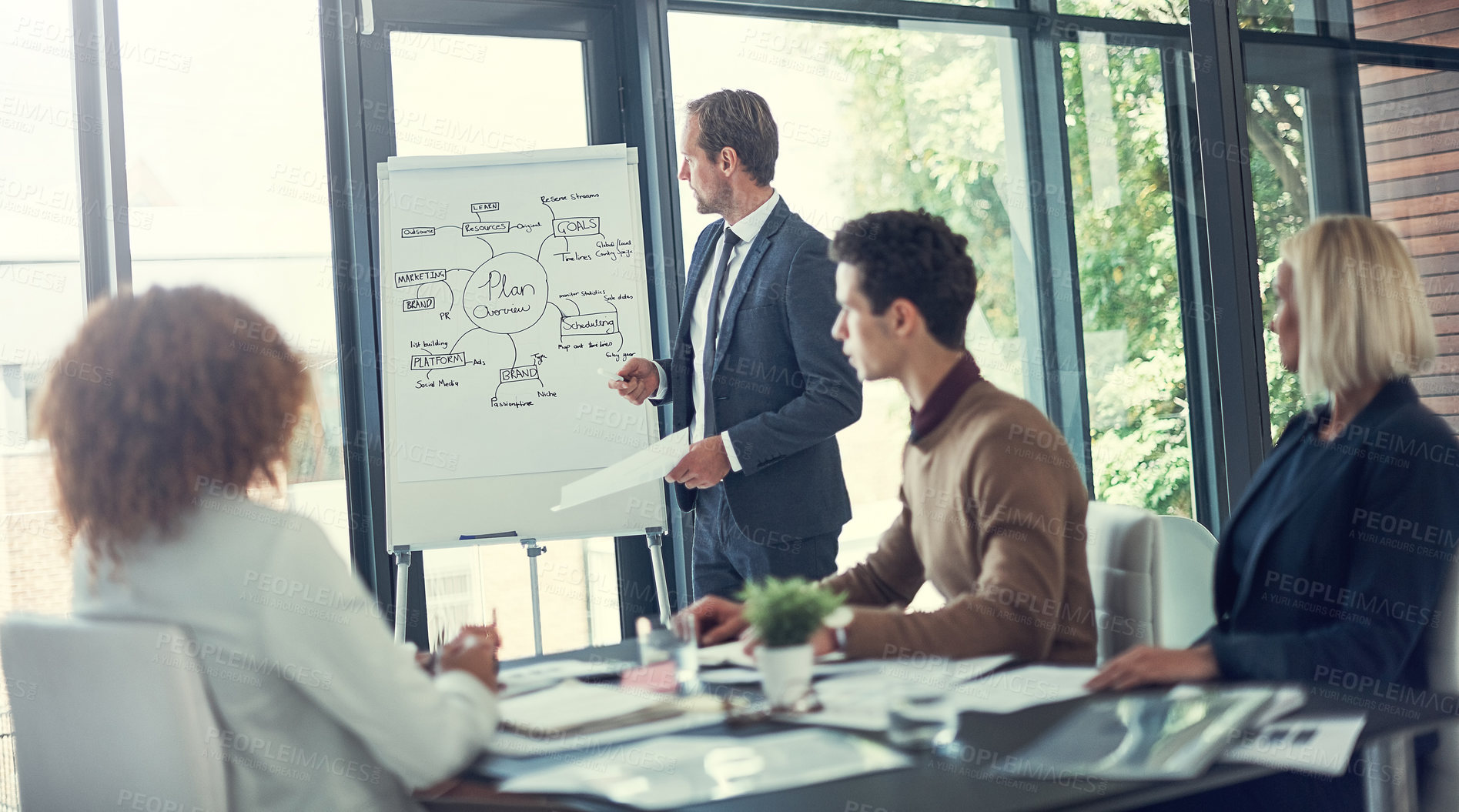 Buy stock photo Cropped shot of a businessman giving a presentation to his colleagues in the boardroom