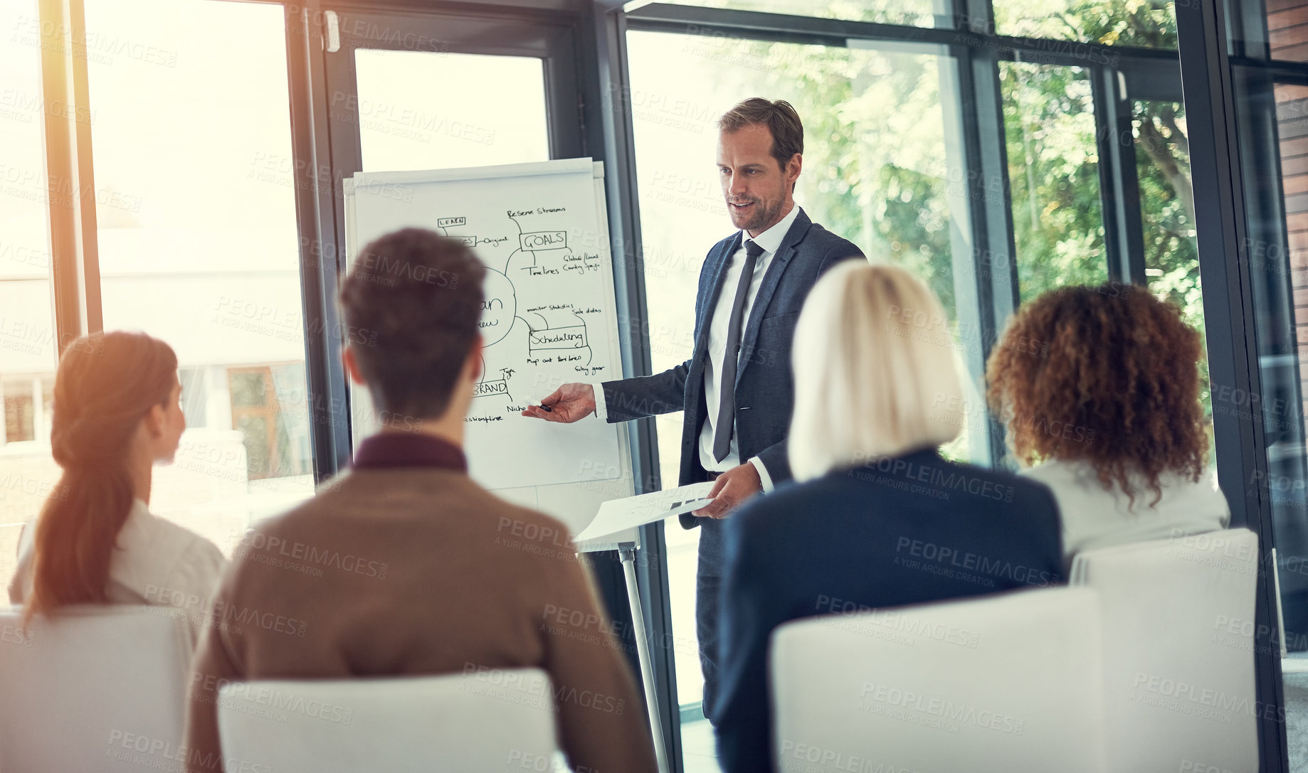 Buy stock photo Cropped shot of a businessman giving a presentation to his colleagues in the boardroom