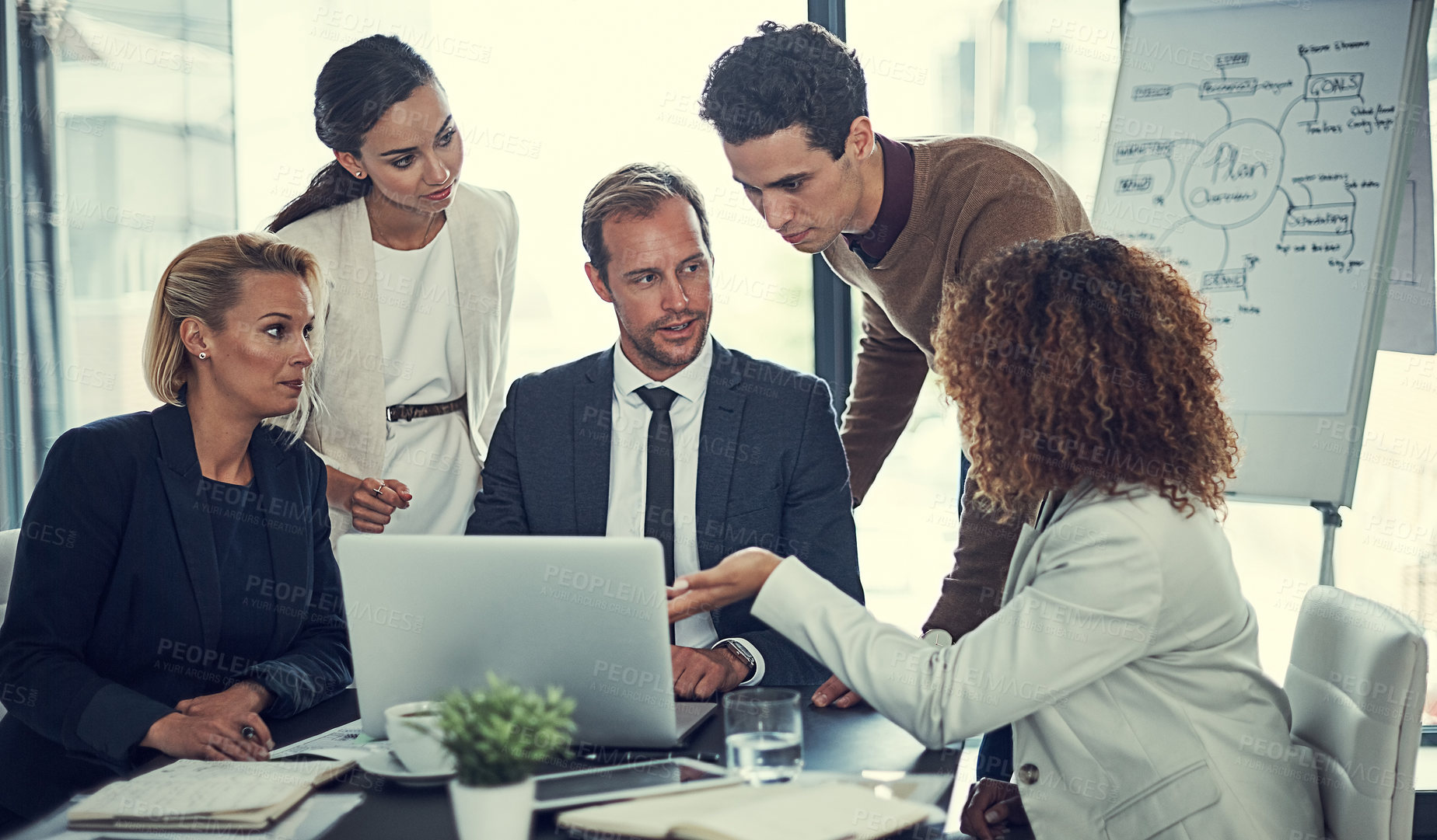 Buy stock photo Cropped shot of businesspeople working together on a laptop in an office