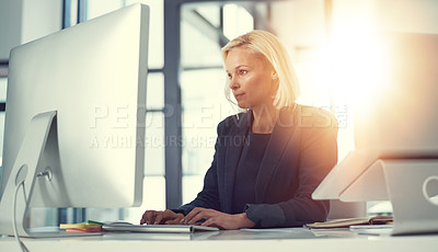 Buy stock photo Shot of a professional businesswoman using a computer at her work desk