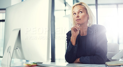 Buy stock photo Shot of a thoughtful businesswoman working at her desk in a modern office