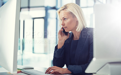 Buy stock photo Shot of a professional businesswoman using a computer and phone at work