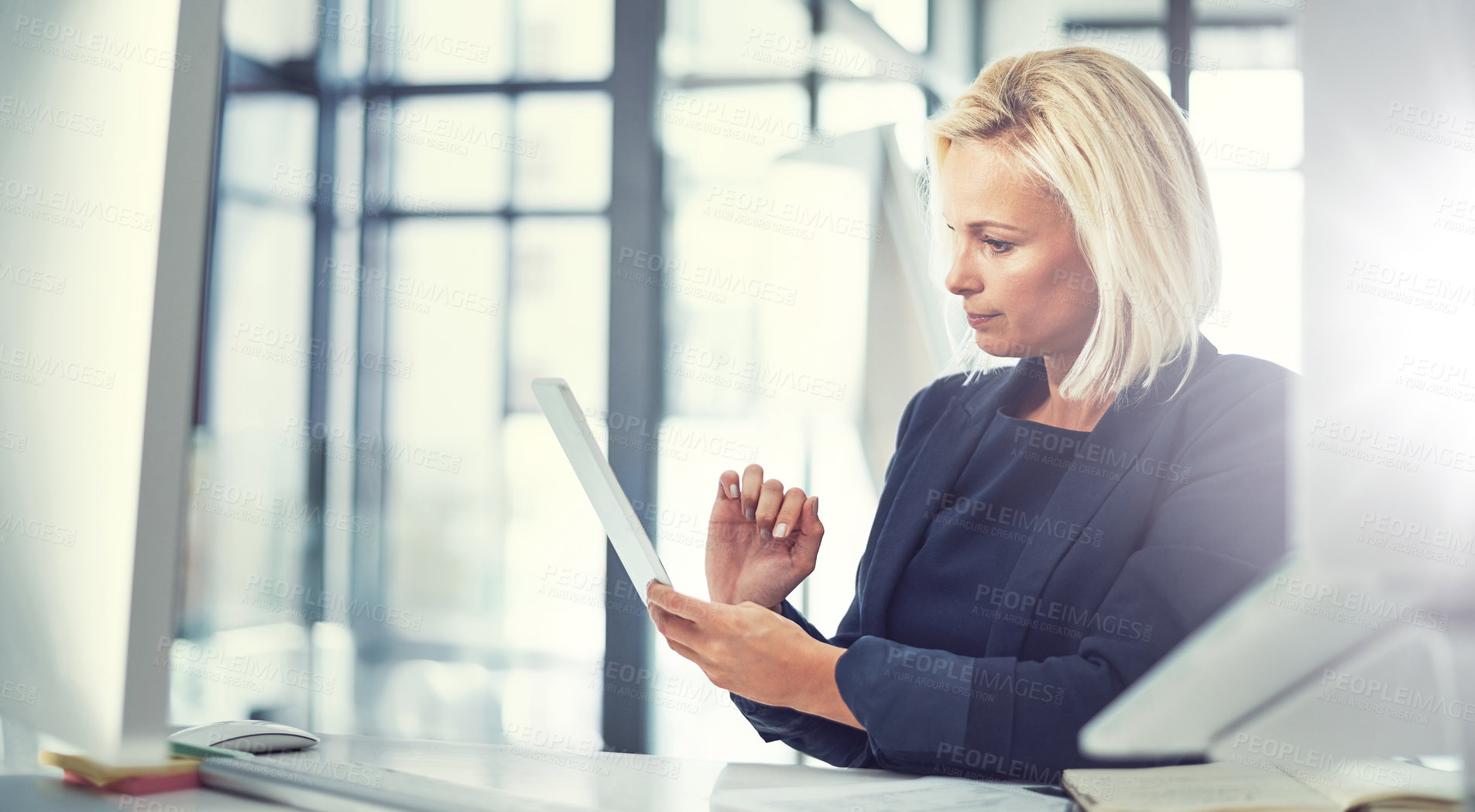 Buy stock photo Shot of a businesswoman using a digital tablet at work