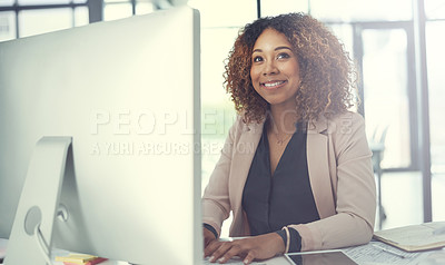Buy stock photo Shot of a thoughtful young businesswoman working at her desk in a modern office