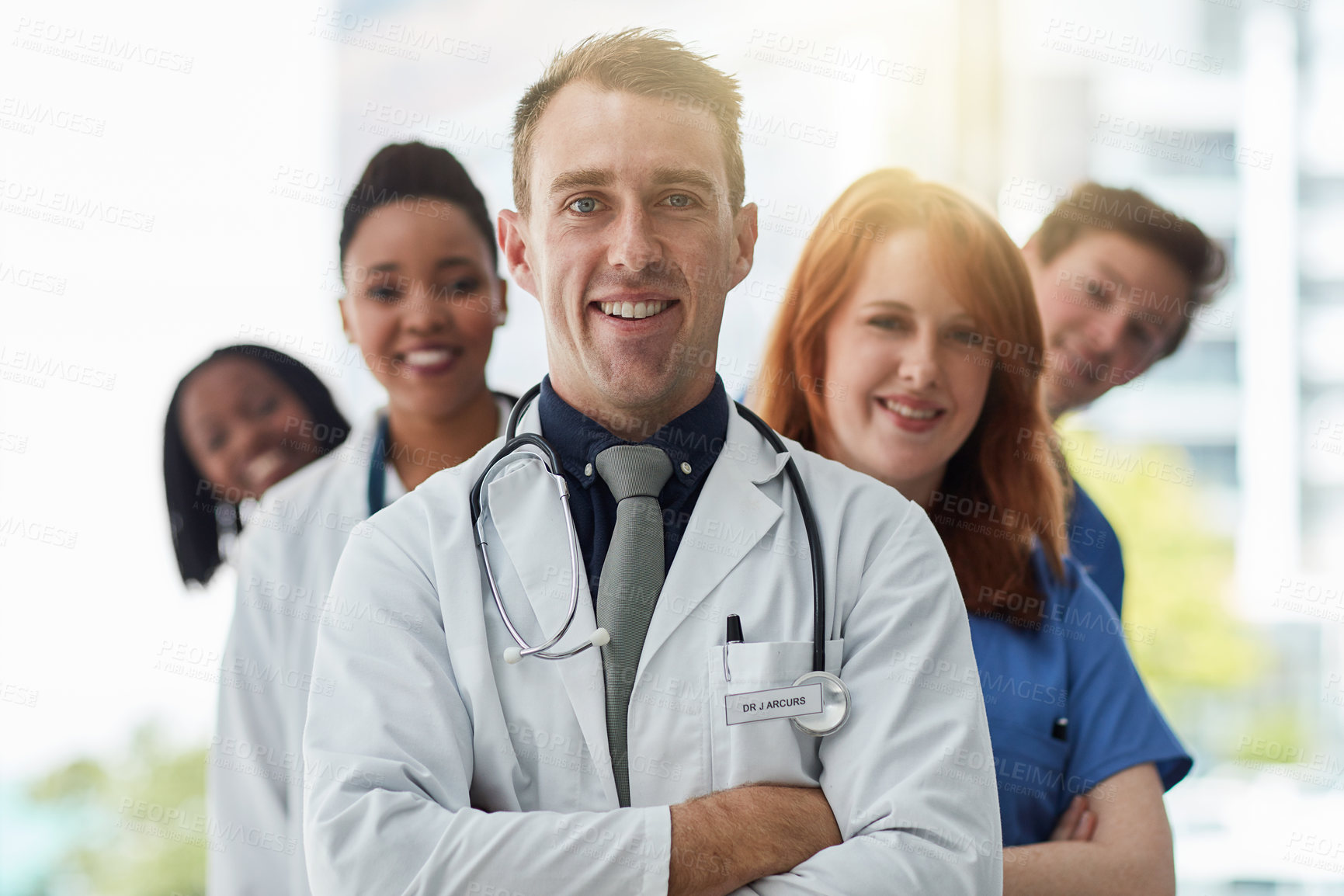Buy stock photo Smile, portrait and medical group in line at hospital for diversity, about us or service. Face, confident people and healthcare team, doctors and professional nurses together with leader arms crossed