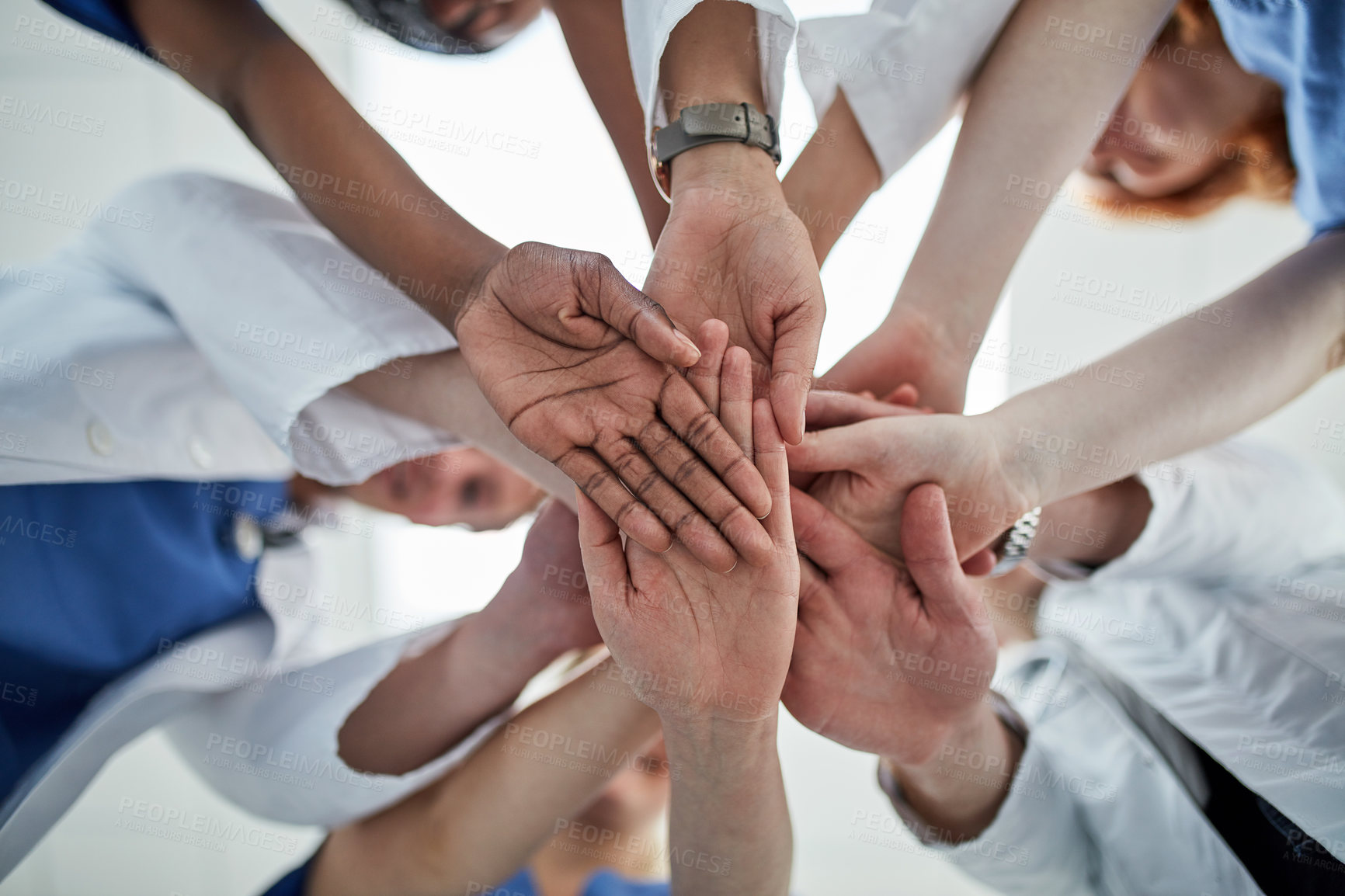 Buy stock photo Doctor, hands together and below with medical team for meeting, unity or motivation at hospital. Low angle or closeup of group piling or touching in collaboration, solidarity or mission at clinic
