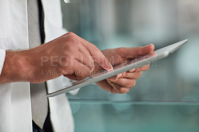Buy stock photo Closeup shot of an unrecognisable doctor using a digital tablet