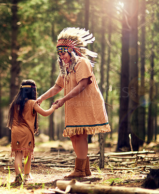 Buy stock photo Native American chief, woman and dance in nature with child, smile and holding hands for bonding in woods. Family, mother and daughter with culture, heritage and traditional clothes on path in forest