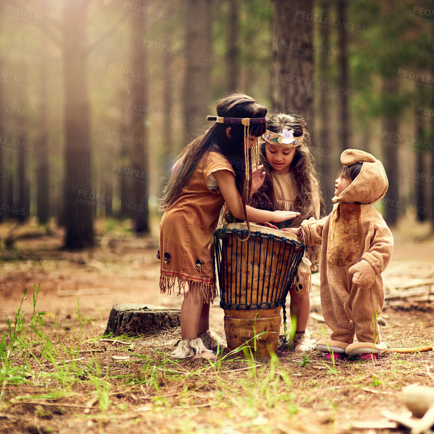 Buy stock photo Native American children, drum and music in nature with playing, bonding and connection in woods. Siblings, kids and instruments with culture, heritage and history in forest with family in California