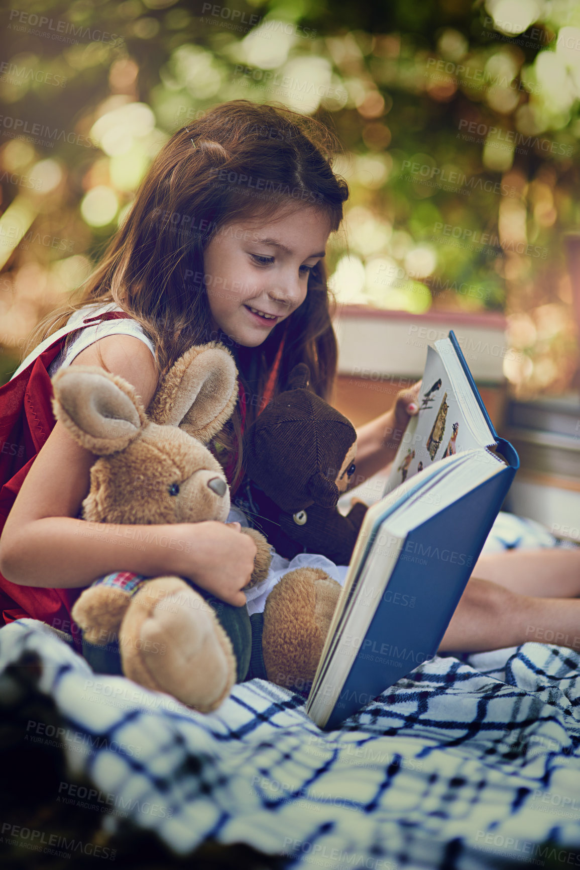 Buy stock photo Cropped shot of a little girl reading a book with her toys in the woods