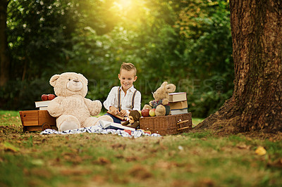 Buy stock photo Shot of a little boy reading to his toys while out in the woods