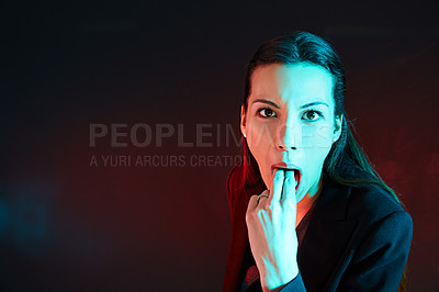 Buy stock photo Portrait of a businesswoman sticking her fingers down her throat against a dark background