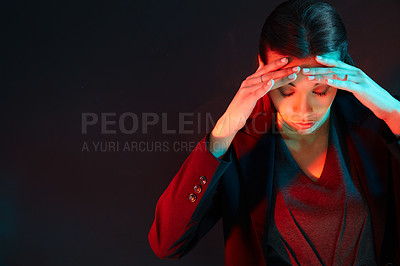 Buy stock photo Shot of an exasperated businesswoman holding her head while standing against a dark background