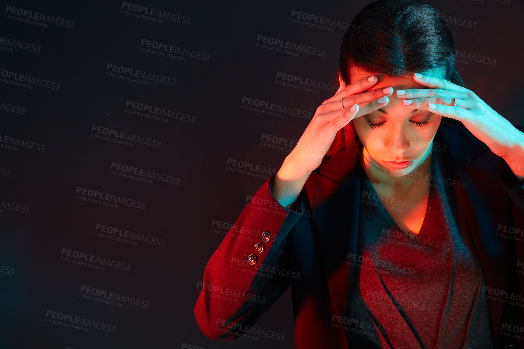 Buy stock photo Shot of an exasperated businesswoman holding her head while standing against a dark background