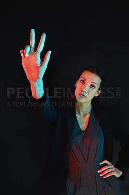 Buy stock photo Portrait of a young businesswoman showing a number with her fingers against a dark background