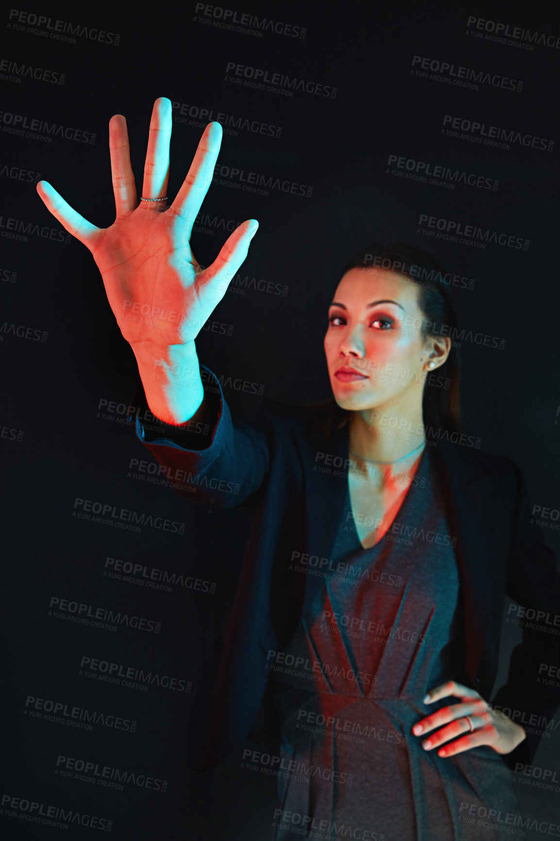 Buy stock photo Portrait of a young businesswoman showing a number with her fingers against a dark background