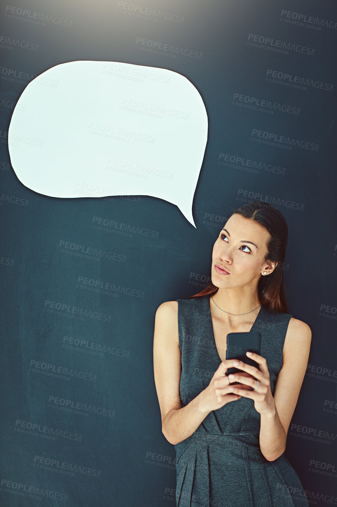 Buy stock photo Shot of a young woman sending a text message against a gray background