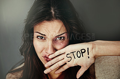 Buy stock photo Portrait of a beaten and bruised young woman with the word 